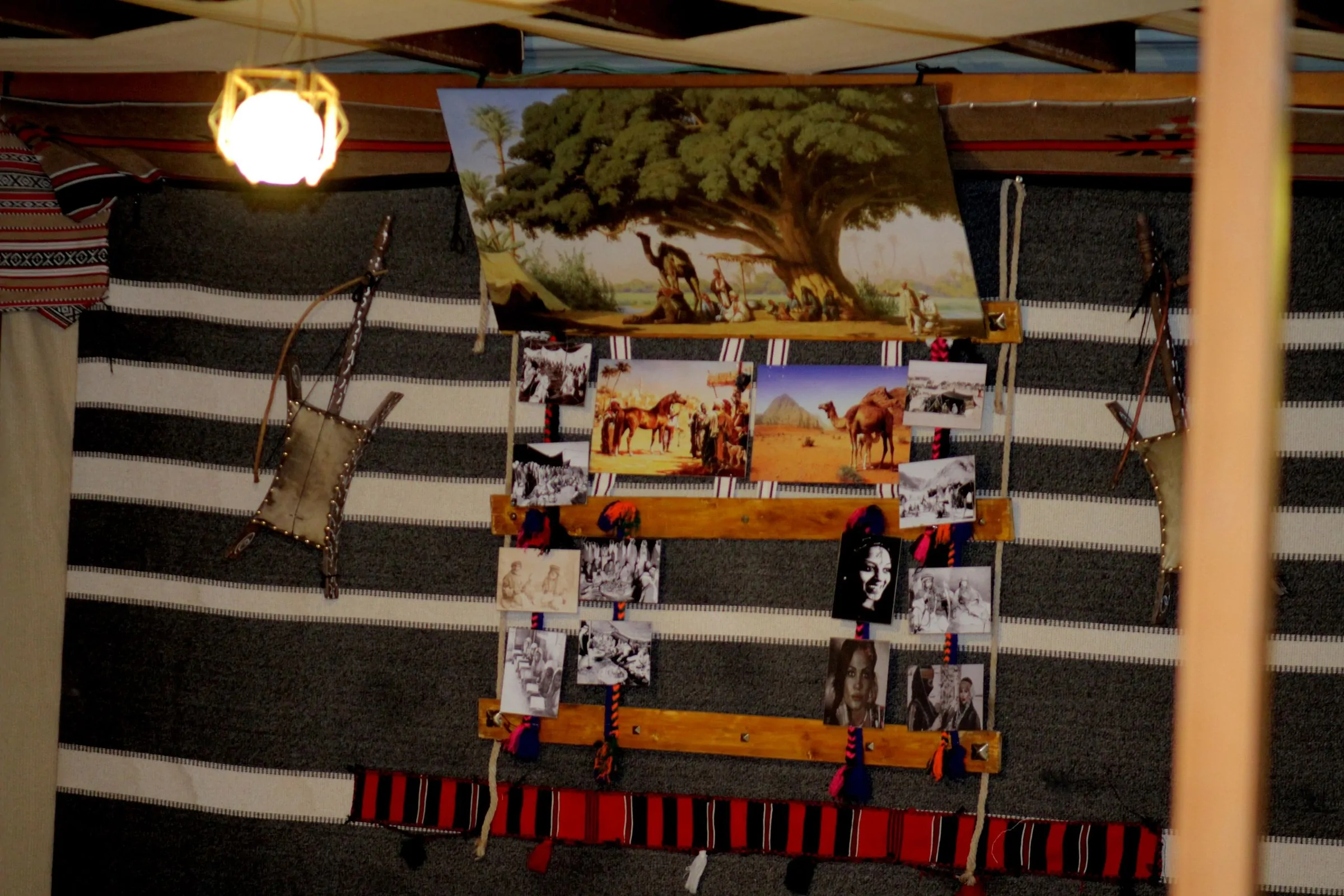 Traditional Bedouin-style wall hanging with photographs and woven textiles inside the camp