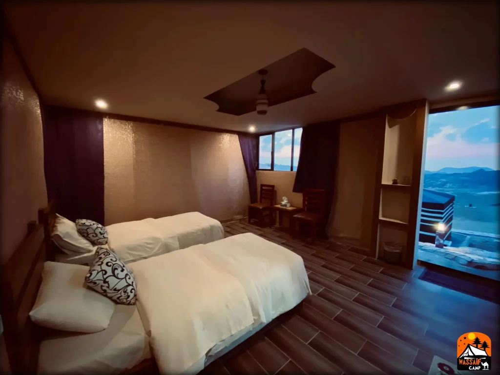 Twin bed room at Petra Wassaif Camp with a window view over the mountains